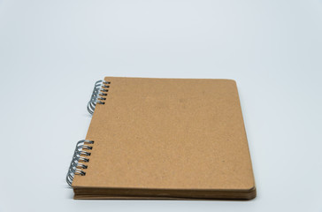 Brown plain notebook with white background and selective focus