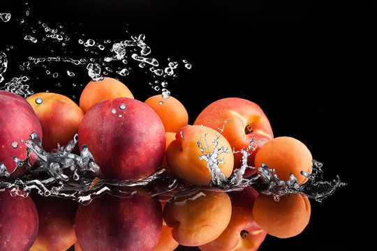 water splash and peaches and apricos on black background
