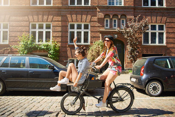 Happy young women riding on a bicycle