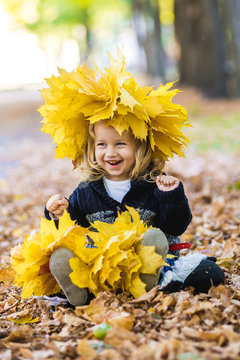 beautiful little girl in a wreath of maple leaves