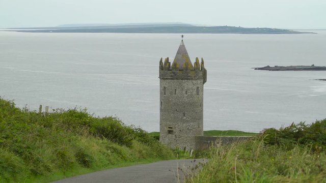 The small Doonagore Castle along the road in the coastal village in Ireland