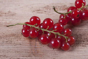 Berries of ripe red currant on wooden background