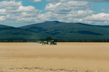 Farm tractor drives in field