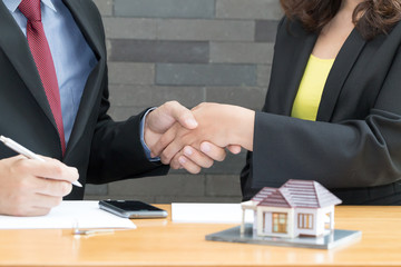 Customer shakes hands and agreement with a real estate agent at