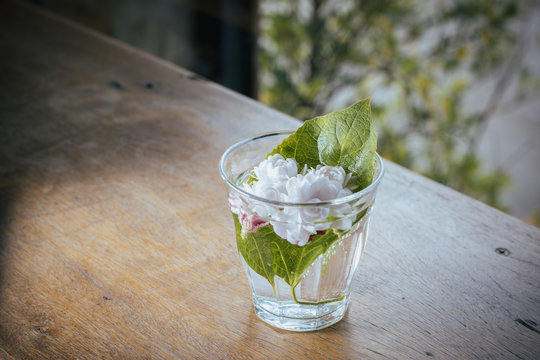 Jasminum in glass on the wooden table backgrand