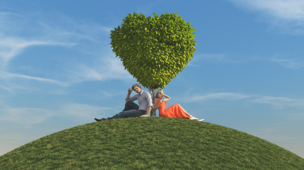 The young couple under a heart shaped tree