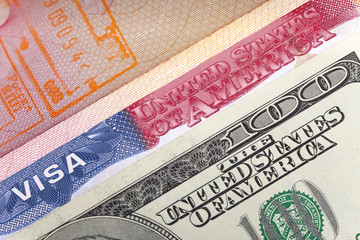 The American visa on page of the international passport and US dollars, closeup..
