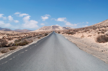 Fuerteventura, Isole Canarie: le montagne del Morro Jable e la strada sterrata per la spiaggia di Sotavento, una delle più famose dell'isola per il windsurf e il kitesurf, il 30 agosto 2016