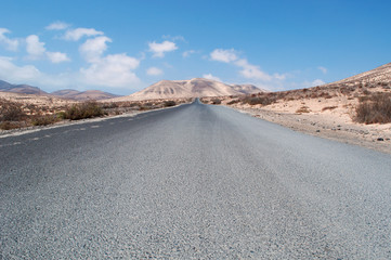 Fuerteventura, Isole Canarie: le montagne del Morro Jable e la strada sterrata per la spiaggia di Sotavento, una delle più famose dell'isola per il windsurf e il kitesurf, il 30 agosto 2016