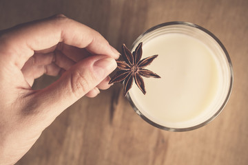 photo of a woman who lay in a glass of milk Dried star anise as a spice to flavor and taste