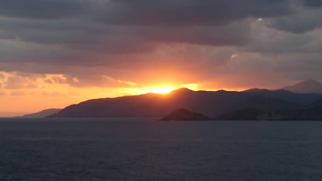 sundawn behind mountains and ocean in Crete, Greece