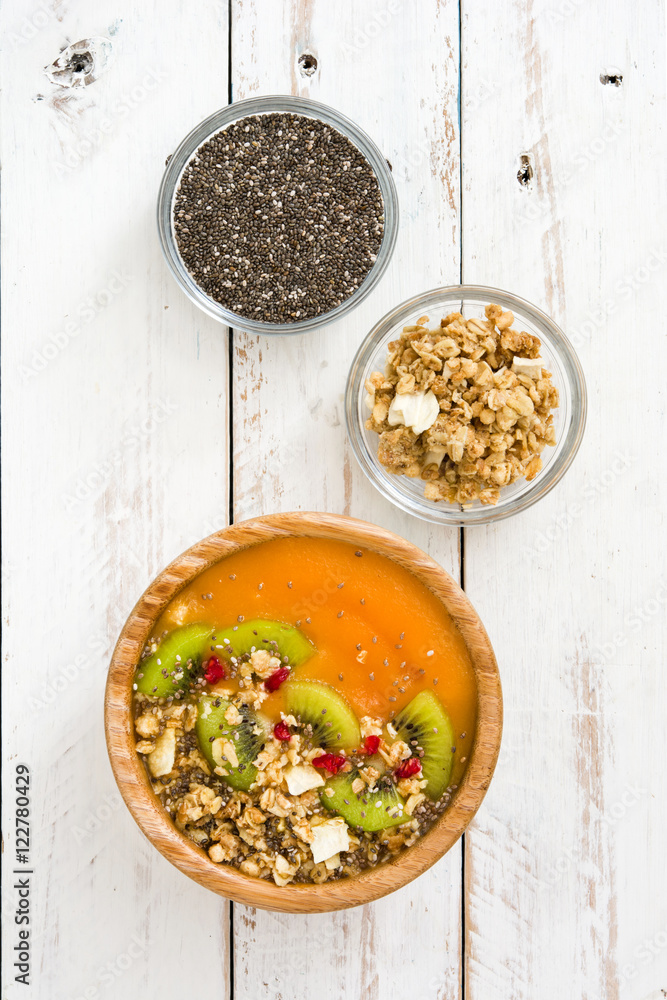 Wall mural Smoothie with fruit,cereals and chia on white wooden table

