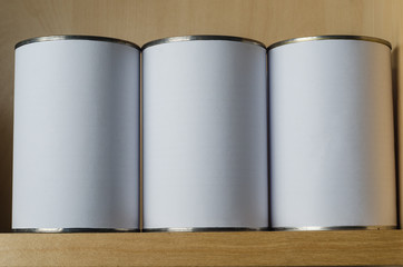Three Tin Cans On Shelf with Blank White Labels