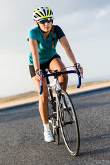 Beautiful young woman cycling on the road.