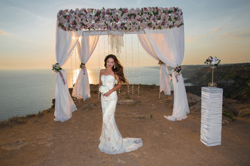 Wedding ceremony. Beautiful brunette bride in fashion dress unde