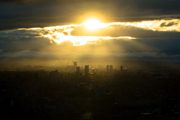 雲間から差し込む光と都市
