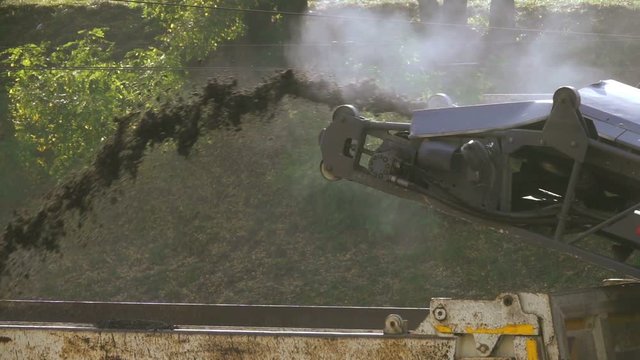 Slow motion milled asphalt cold milling machine pour in the truck