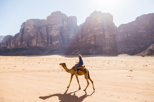 Woman Riding On Camel In Desert