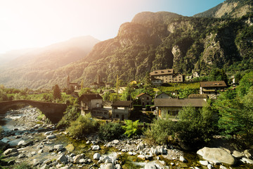 Roman bridge at Giornico village in summer sun light on Leventina valley, Switzerland