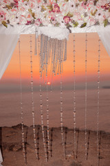 Sunset. Wedding ceremony arch closeup with flower arrangement an