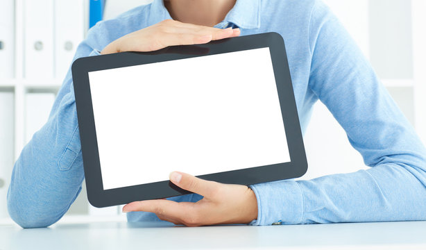 Mid section of a young businesswoman holding tablet in hands sitting in the office.