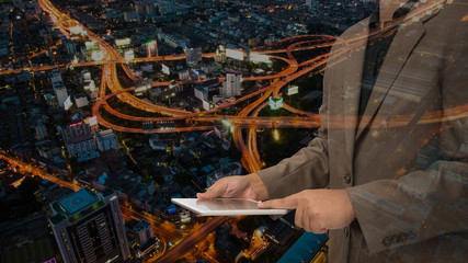 double exposure of business man using tablet with night modern c