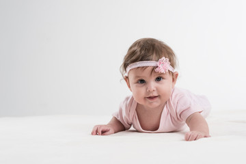 Glückliches Baby liegt spielend auf Boden