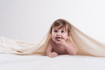 Naklejka premium glückliches baby unter decke werbefoto