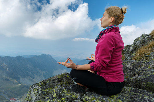 Woman doing yoga on mountain