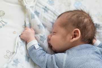 Neugeborenes Baby schläft zufrieden auf Decke