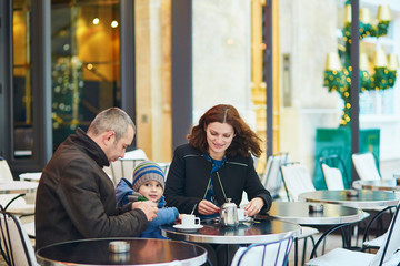 Happy family of three in outdoor cafe