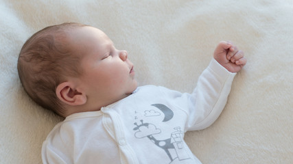 Neugeborenes Baby schläft zufrieden auf Decke