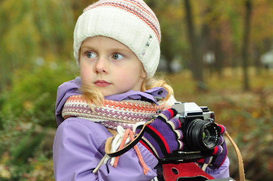 child with a camera in nature