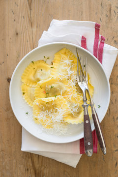 Butter and thyme ravioli served with grated parmesan cheese