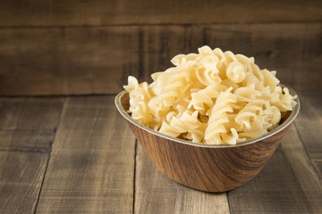 Fusilli pasta in wooden bowl