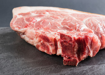Piece of pork meat on a black stone table