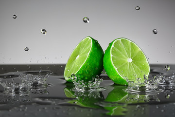 Lime with water drops on grey background - obrazy, fototapety, plakaty