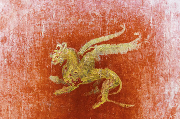 detail of the fresco in Pompeii with winged griffin on a red bac