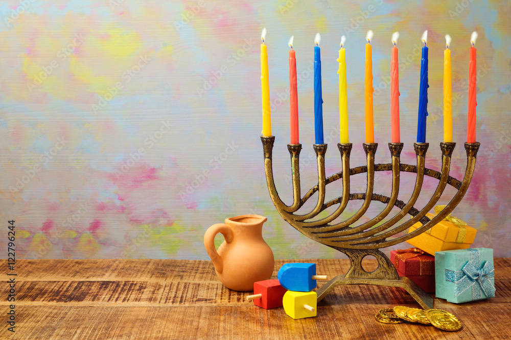 Wall mural jewish holiday hanukkah celebration with menorah, dreidel, gifts and oil jug on wooden table