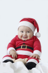 happy baby sitting with a Santa Claus costume in a white background