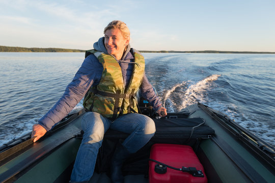 Smiling woman is operating of boat on the sea