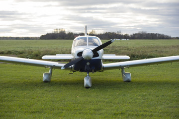 Front view of private small plane against cloudy sky