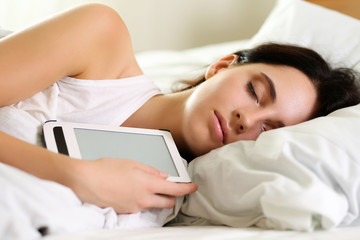 Obraz na płótnie Canvas Young beautiful brunette woman portrait lying in bed sleeping