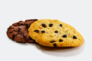 Cookies with raisins and chocolate lying on white background.