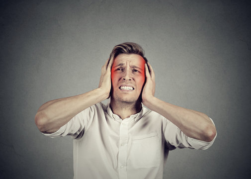 man with headache isolated on gray wall background