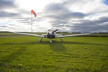 Fototapeta na wymiar Small private aircraft parked against sunny sky