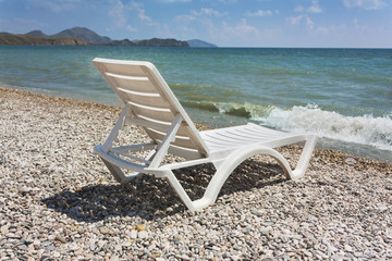 Fototapeta na wymiar white chaise lounge on the beach