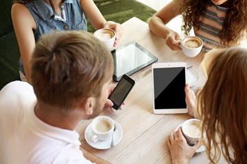 Friends with tablet drinking coffee in cafe