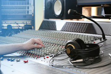Hand on mixer in a recording studio, close up