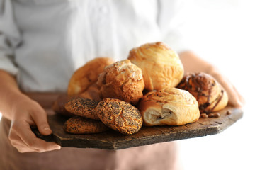 Woman holding fresh bakery products, closeup